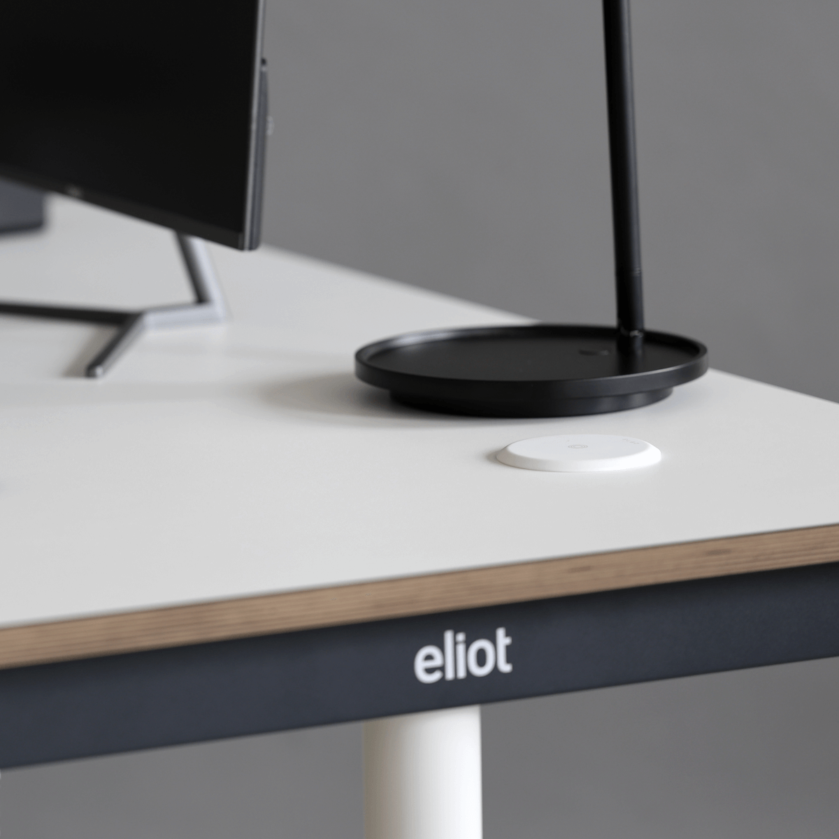 weißer wireless charger auf einem weißen Eliot Tisch, daneben eine Leuchte