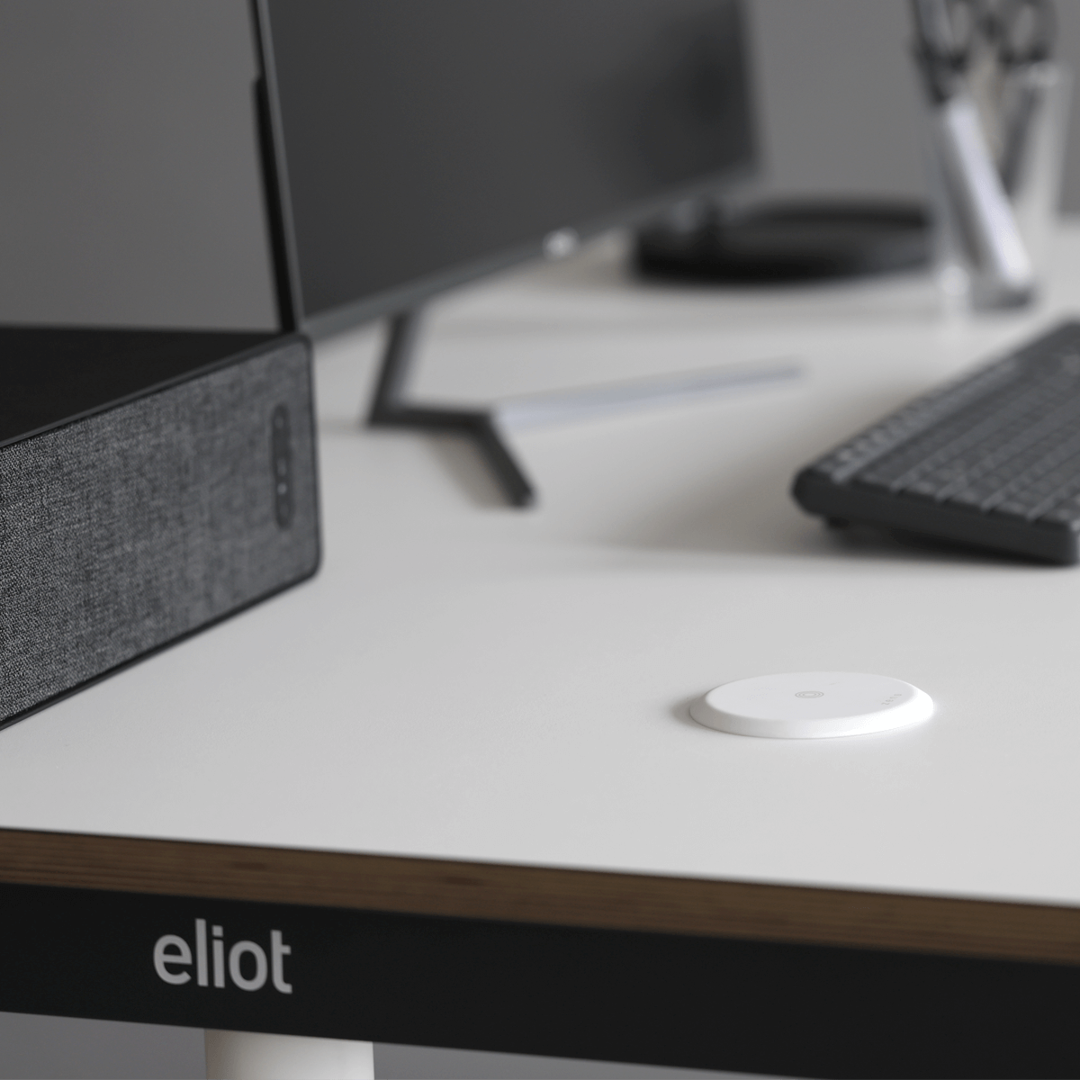 weißer wireless charger auf einem weißen Eliot Tisch