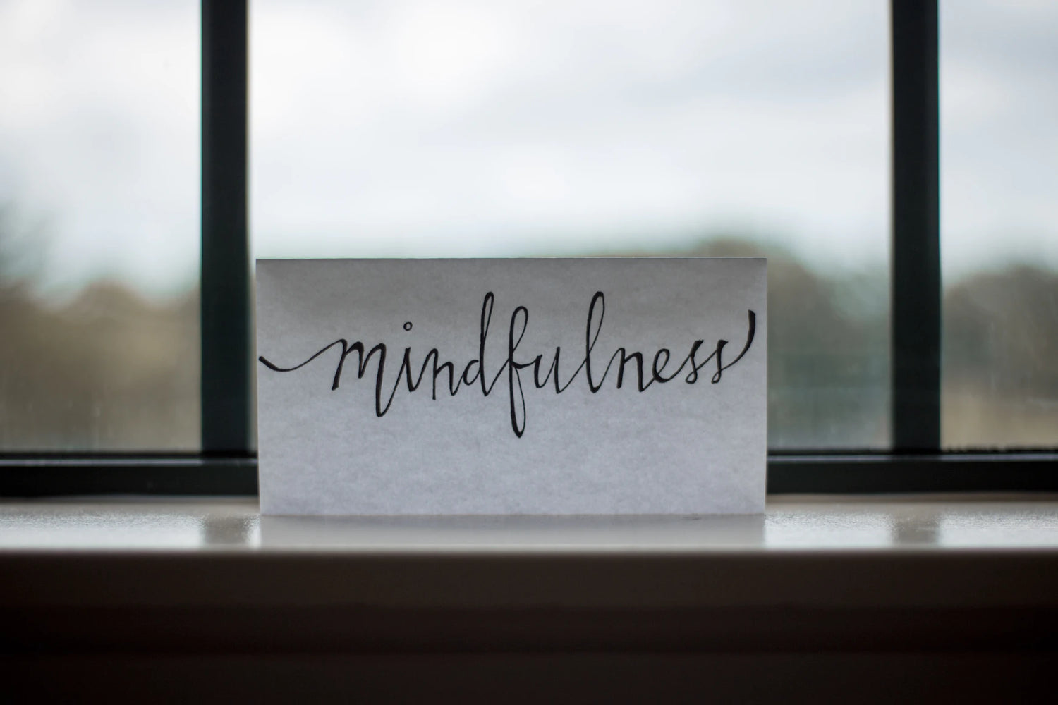 Ein Zettel mit der Aufschrift "mindfulness" steht auf einem Fensterbrett