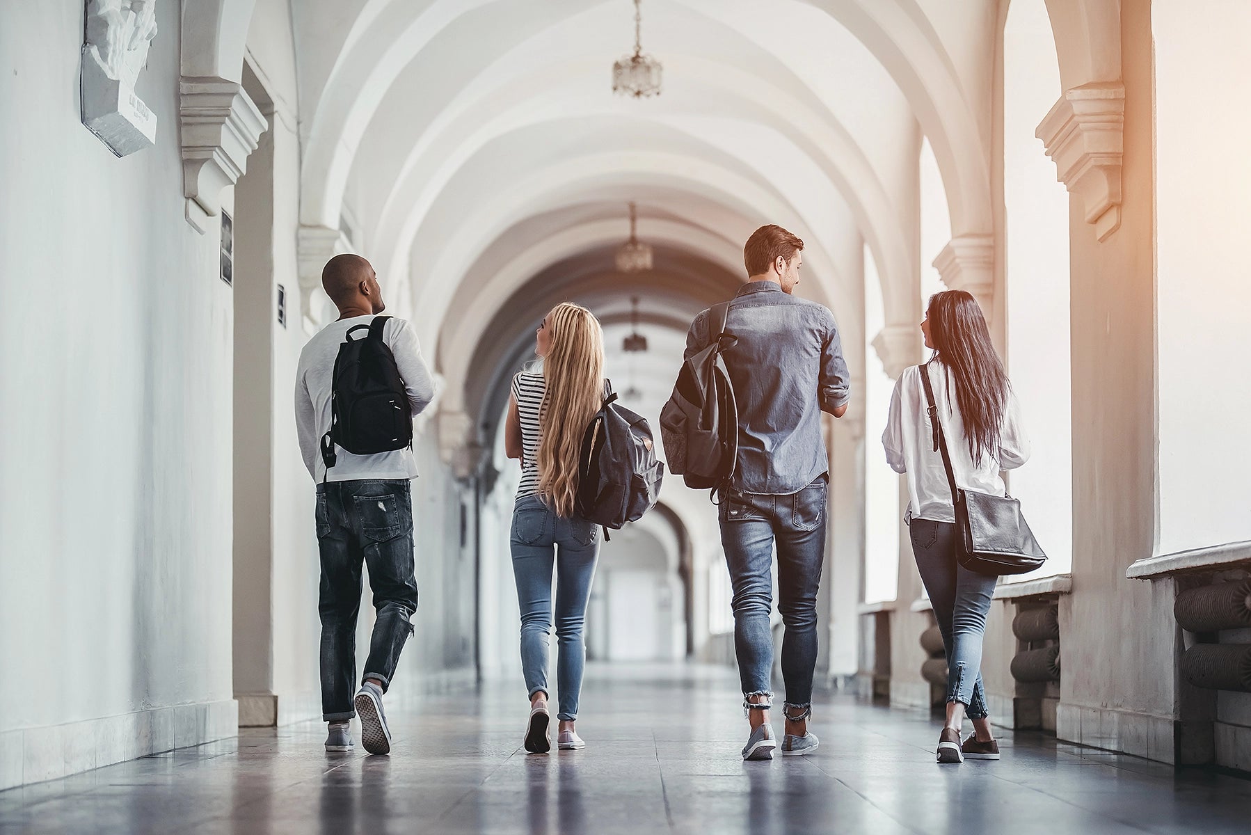 Studenten, die einen Gang entlang gehen, mit dem Rücken zur Kamera