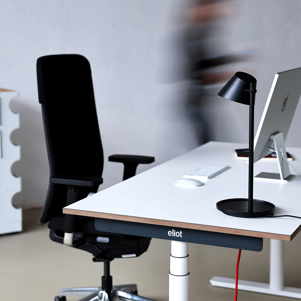 freigestellter ergonomischer Bürostuhl Spyn Plus Black vor Eliot Schreibtisch